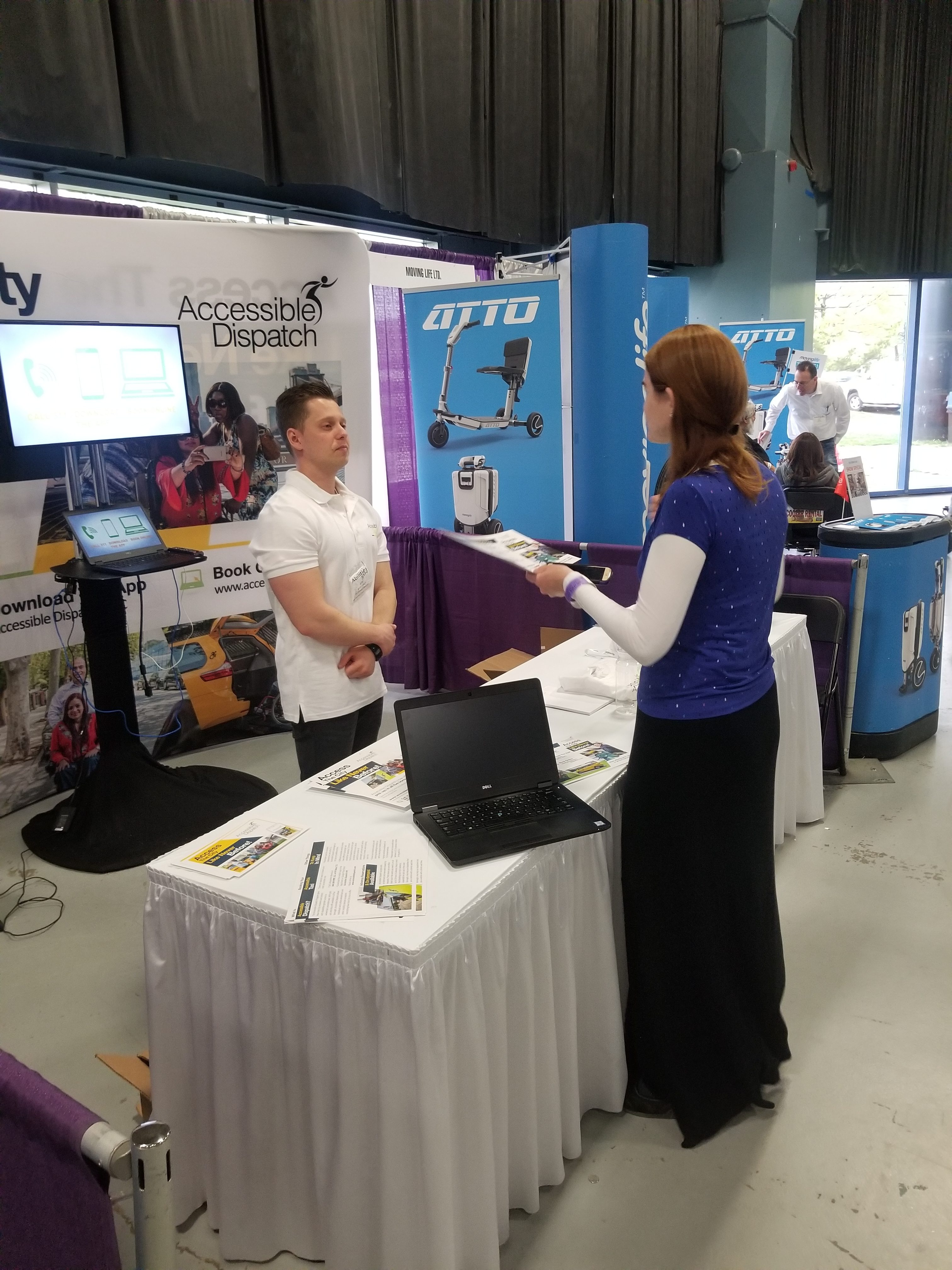 An attendee of the 2018 abilities expo speaking with a team member of the Accessible Dispatch program