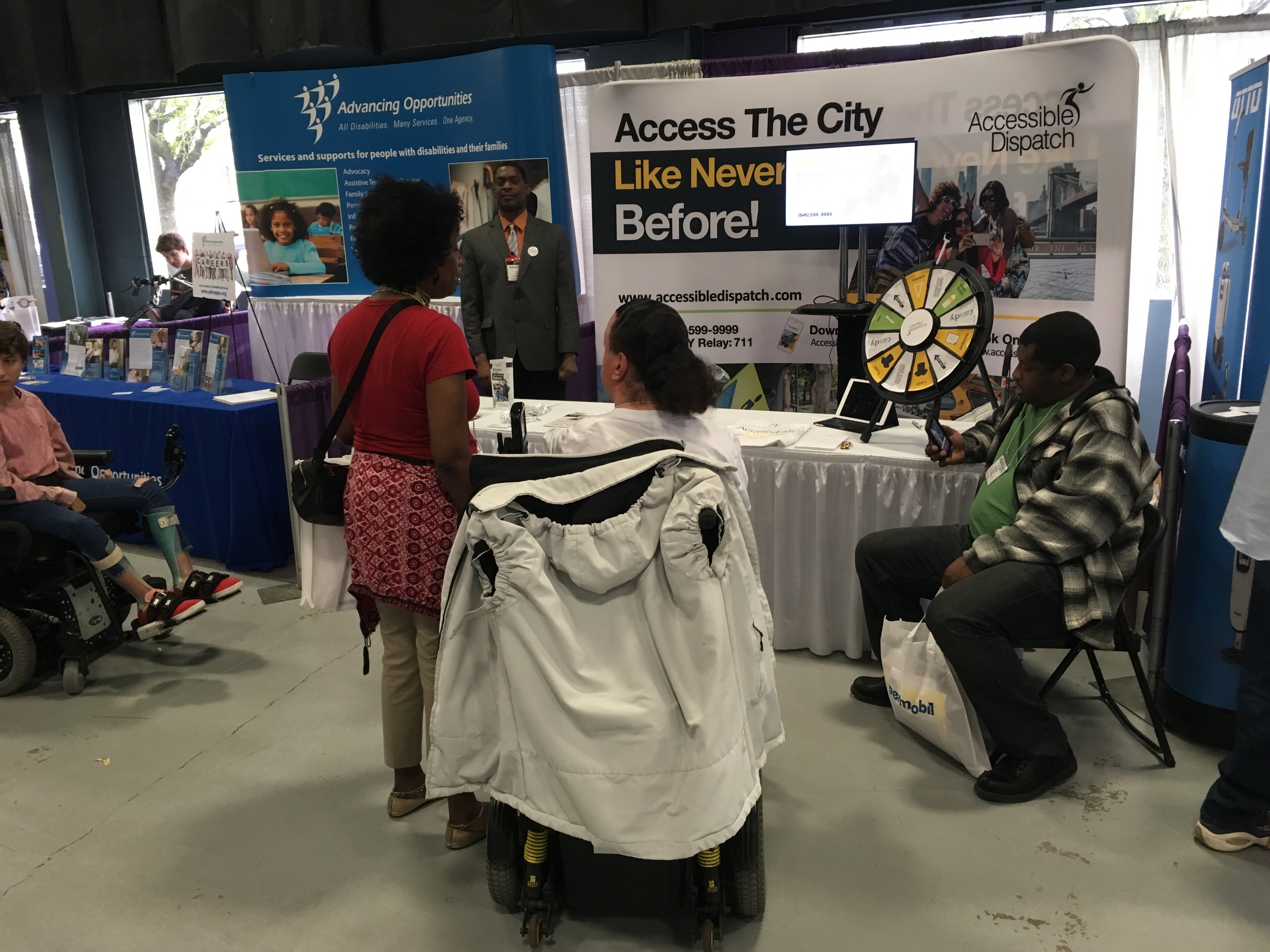 2018 abilities expo attendee standing in front of the Accessible Dispatch booth and speaking with one of the program's dispatchers