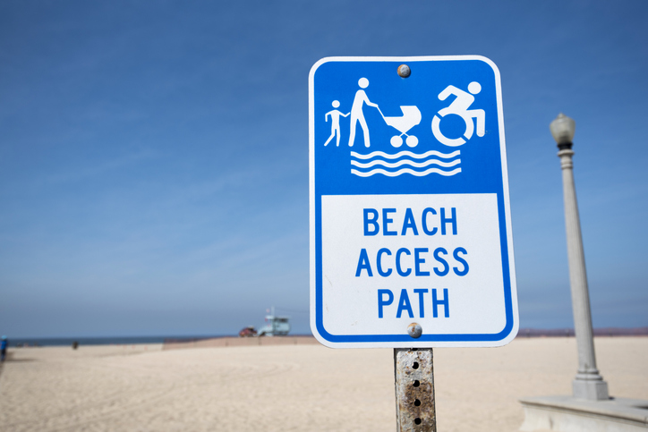 Sign board indicating mobility device accessible path at the beach 