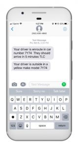 Cell phone open to text messages showing a trip confirmation and notification that the driver has arrived. Text messages read 'Your driver is en route in car number 7Y74. They should arrive in 5 minutes TLC’ and ‘Your driver is outside in a yellow make model 7Y74.’