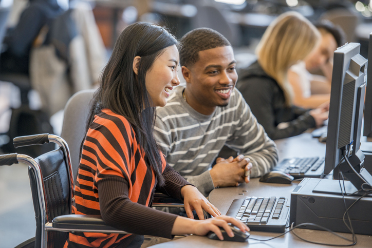 • A multi-ethnic group of college age students are working on computers in the lab during a university class.